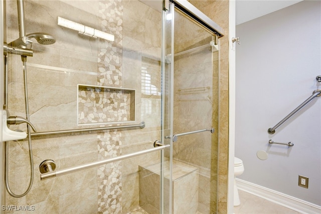 bathroom with toilet, tile patterned floors, and an enclosed shower