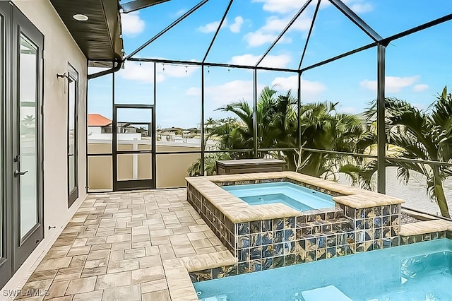 view of swimming pool with an in ground hot tub, a patio area, and glass enclosure