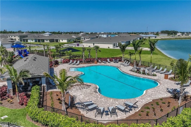 pool with a residential view, a water view, fence, and a patio