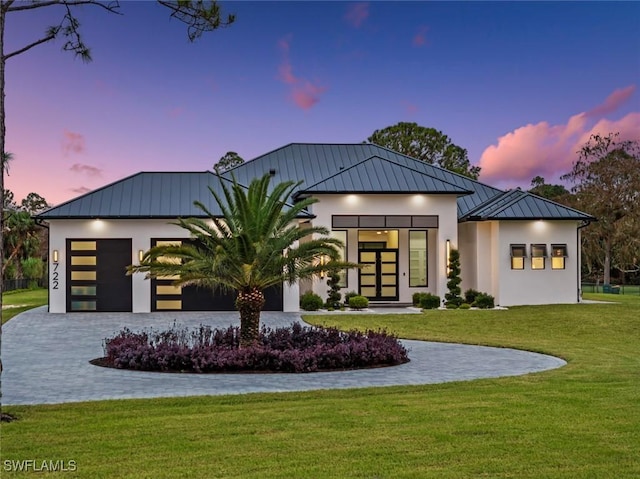 view of front of property featuring a garage and a yard