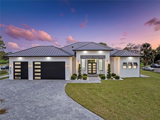 view of front of home featuring a garage, a yard, and french doors