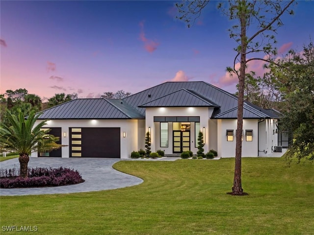 view of front of house featuring a garage and a lawn