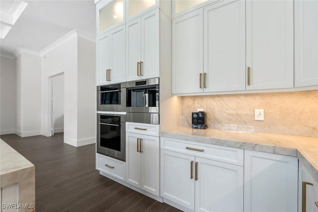 kitchen with white cabinetry, backsplash, and crown molding