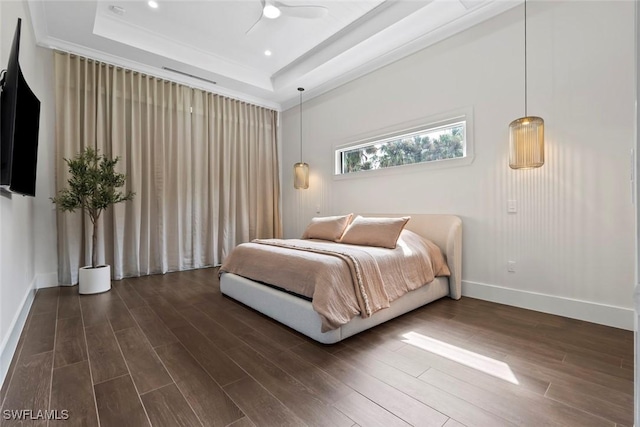 bedroom featuring dark hardwood / wood-style floors, a raised ceiling, and ceiling fan