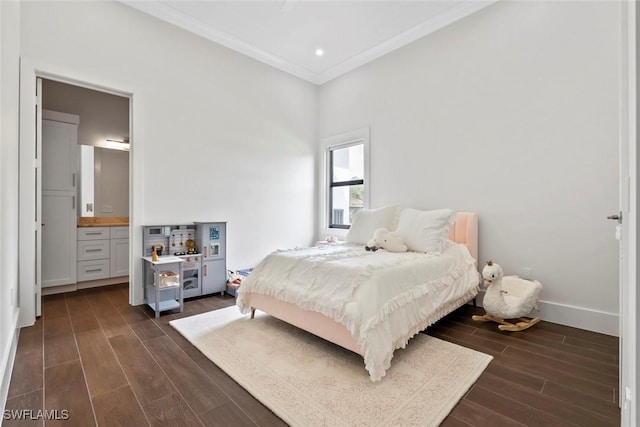 bedroom with connected bathroom, crown molding, and dark wood-type flooring