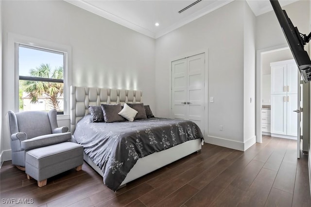 bedroom featuring a towering ceiling, ornamental molding, and dark hardwood / wood-style flooring