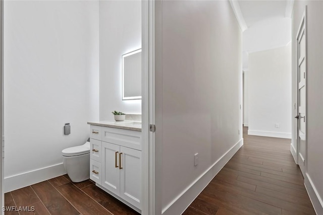 bathroom with hardwood / wood-style flooring, vanity, and toilet