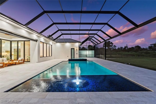 pool at dusk featuring a lanai, an outdoor hangout area, and a patio