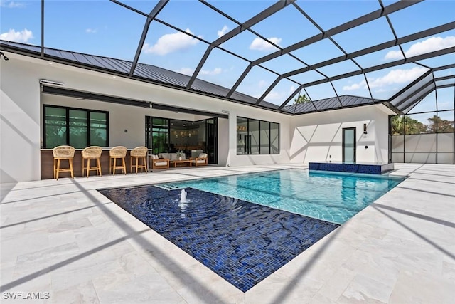 view of swimming pool with a bar, a patio, pool water feature, and glass enclosure