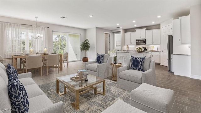 living room with a notable chandelier and sink