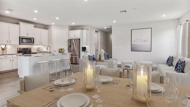 dining space featuring light hardwood / wood-style floors and sink