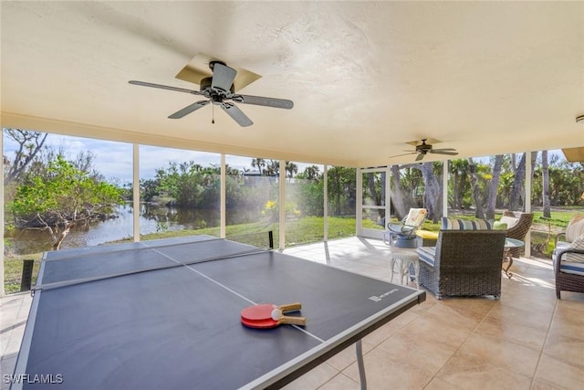 view of patio with ceiling fan and a water view