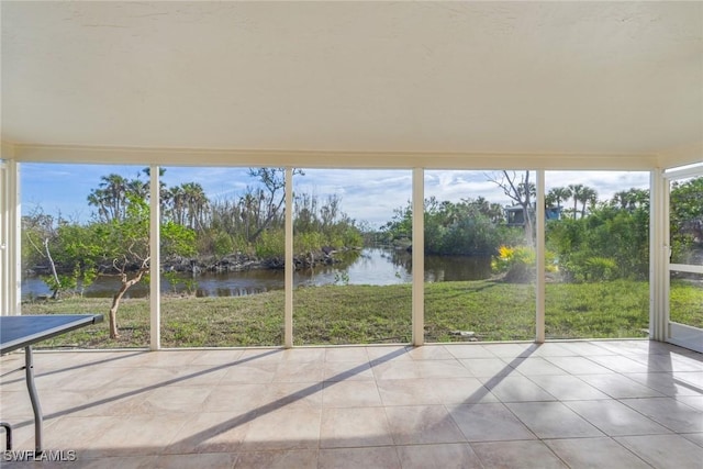 unfurnished sunroom with a water view