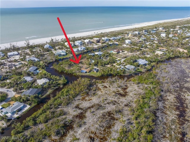 drone / aerial view featuring a water view and a view of the beach