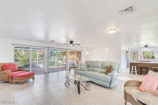 living room featuring light tile patterned floors and ceiling fan