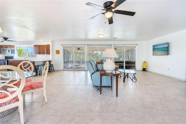 tiled living room featuring plenty of natural light and ceiling fan