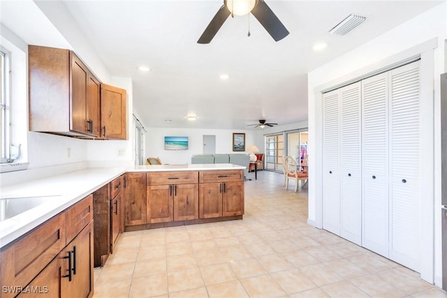 kitchen with kitchen peninsula, ceiling fan, and sink