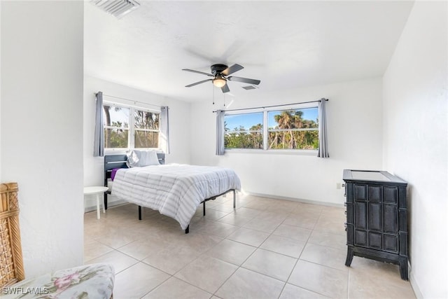 bedroom with ceiling fan, light tile patterned flooring, and multiple windows