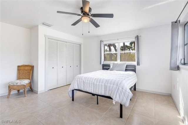 tiled bedroom featuring ceiling fan and a closet