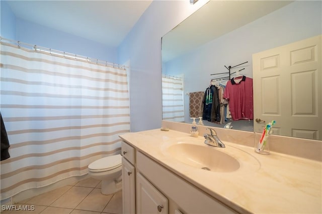 bathroom with toilet, vanity, and tile patterned floors