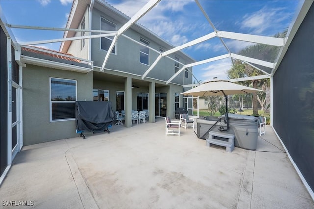 view of patio with a hot tub, a lanai, and a grill