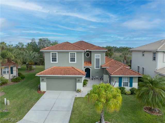 mediterranean / spanish house with a garage and a front lawn