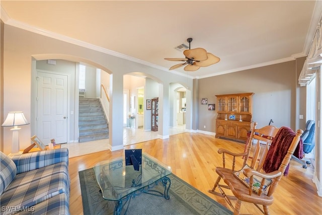 living room featuring light hardwood / wood-style flooring, ceiling fan, and crown molding