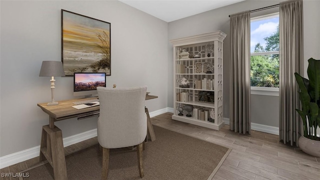 office area featuring light wood-style flooring and baseboards