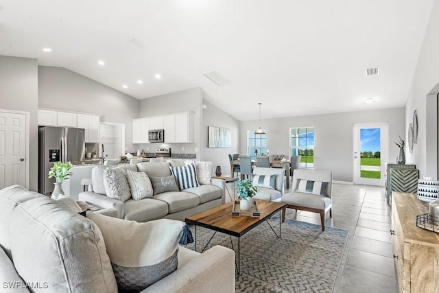 living room with high vaulted ceiling and light tile patterned flooring