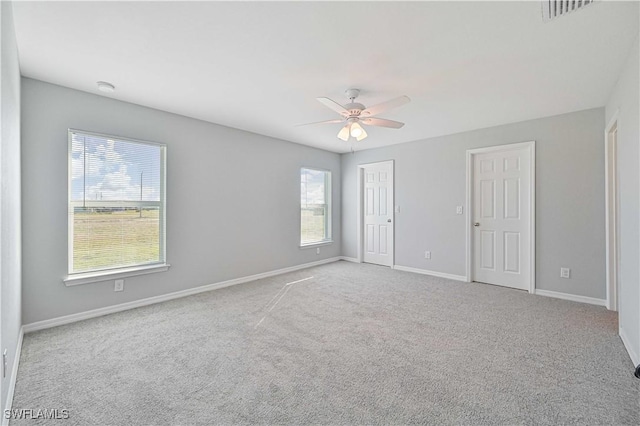 carpeted spare room with ceiling fan