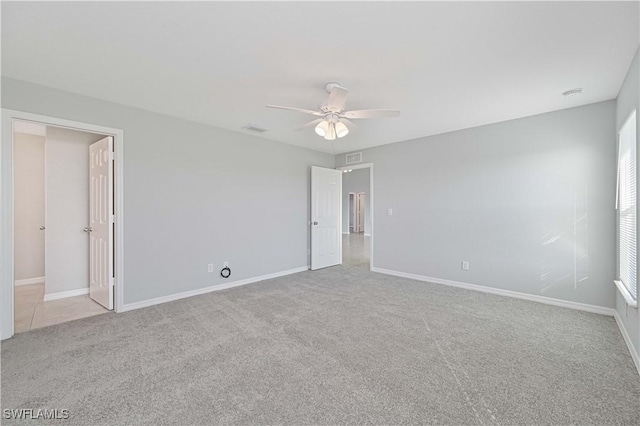 carpeted spare room with ceiling fan