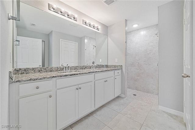 bathroom featuring tiled shower and vanity