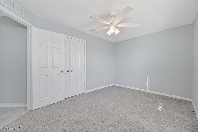 unfurnished bedroom featuring ceiling fan, light carpet, and a closet