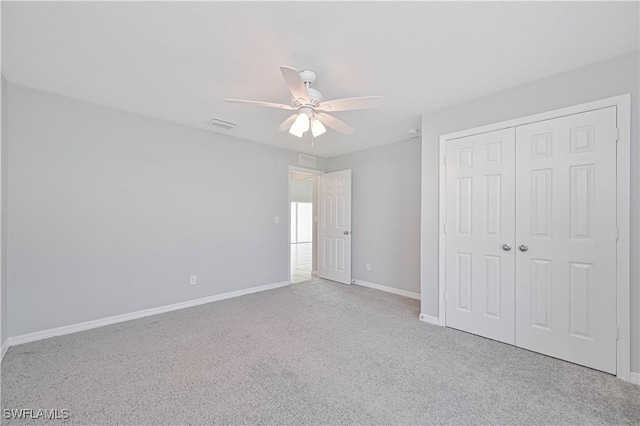 unfurnished bedroom featuring ceiling fan, light carpet, and a closet