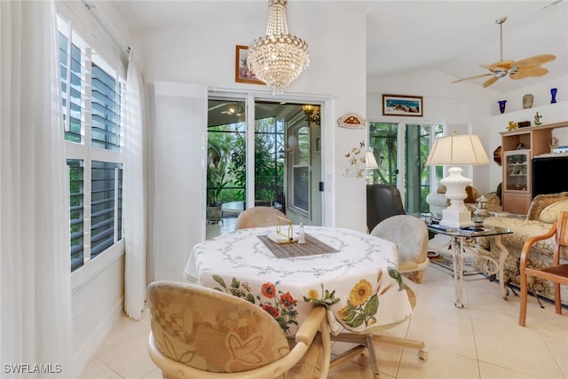 dining area featuring vaulted ceiling, light tile patterned flooring, and ceiling fan with notable chandelier