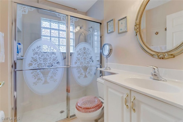 bathroom with a shower with shower door, toilet, and vanity