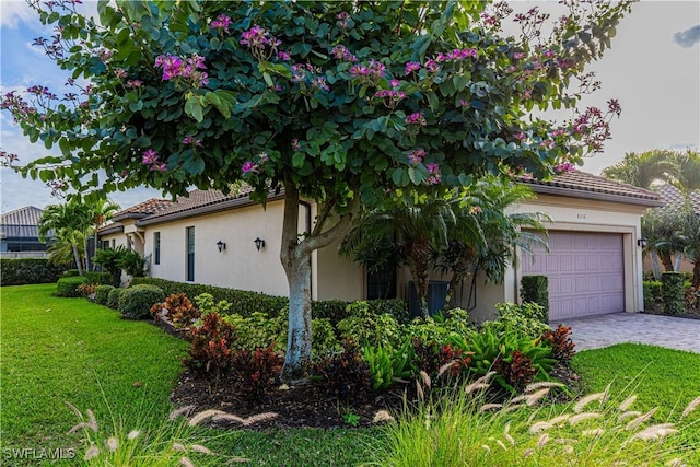 mediterranean / spanish-style house with a garage and a front lawn