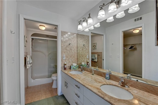 bathroom featuring tile patterned floors, vanity, a shower with shower door, and toilet