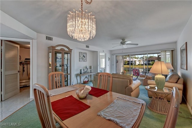 tiled dining room featuring ceiling fan with notable chandelier