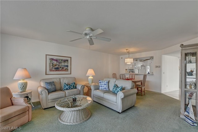 living room featuring ceiling fan with notable chandelier