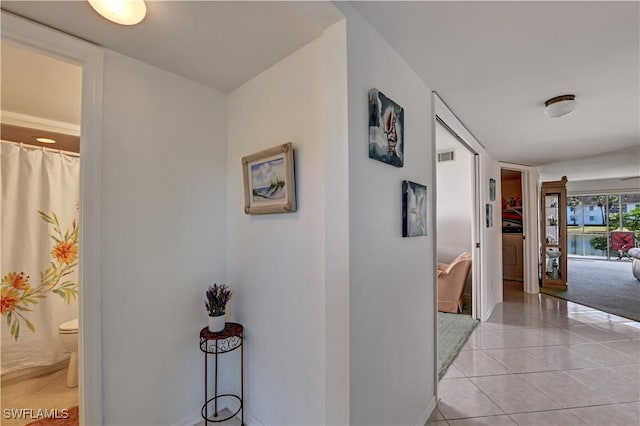 corridor featuring light tile patterned floors and washer / dryer