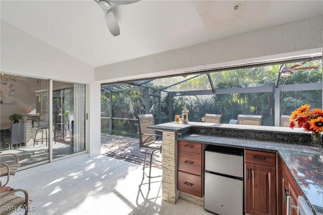 sunroom with ceiling fan and lofted ceiling