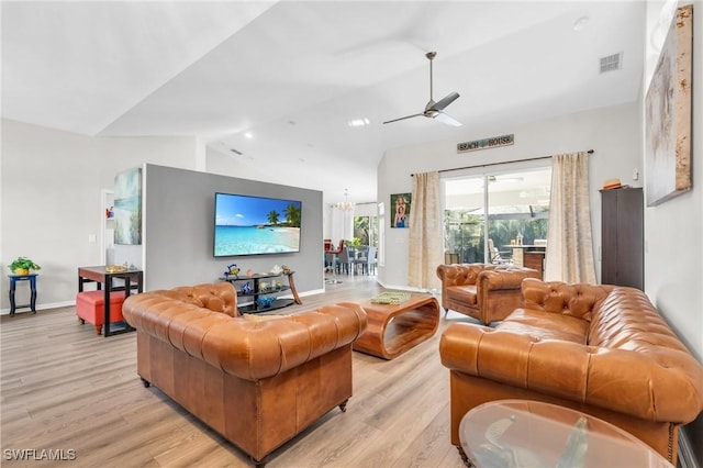 living room featuring ceiling fan with notable chandelier, light hardwood / wood-style floors, and lofted ceiling