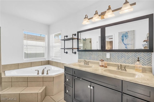 bathroom with tile patterned floors, vanity, and tiled bath