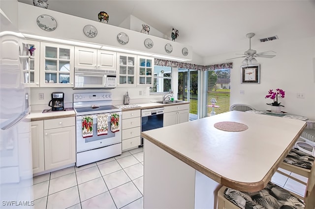 kitchen with white cabinets, a kitchen bar, and white appliances