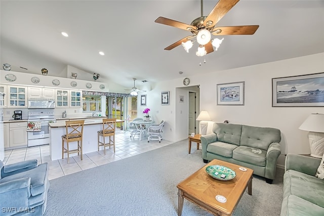 living room with ceiling fan, light tile patterned flooring, and lofted ceiling