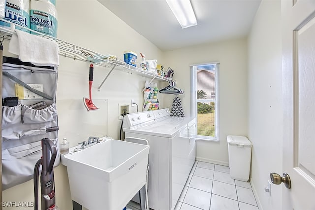 washroom with washer and dryer, light tile patterned floors, and sink