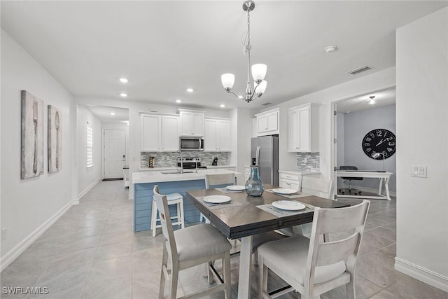 dining room featuring light tile patterned flooring, sink, and a notable chandelier