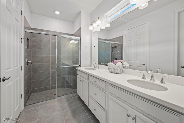 bathroom with tile patterned floors, vanity, and a shower with door