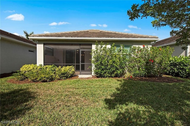 rear view of house featuring a lawn